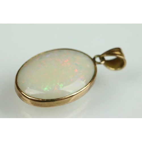 31A - Opal 14ct gold pendant, the oval cabochon cut precious white opal displaying violet, blue, yellow, g... 