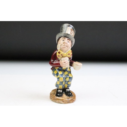 57 - Four Alice In Wonderland porcelain figures to include Royal Worcester Alice candle snuffer, modelled... 