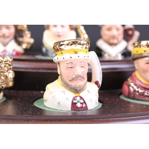 97 - Set of Six Royal Doulton 'Kings & Queens of the Realm' tiny character jugs on wooden display stand (... 