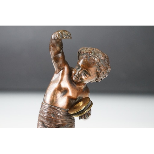 189 - Antique cast bronze putti figurine depicting a classical putti with symbols raised on a fluted cast ... 