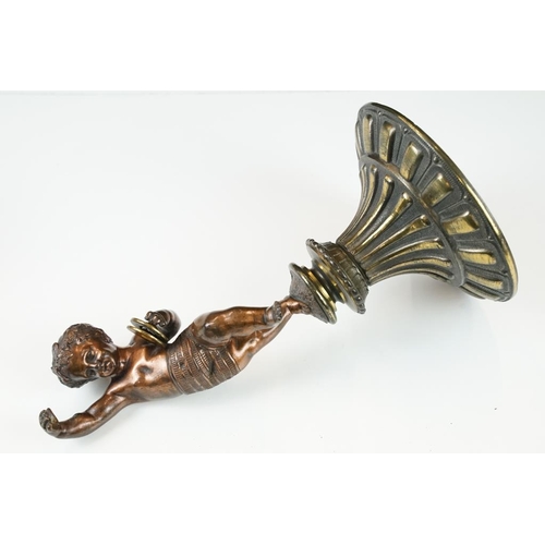 189 - Antique cast bronze putti figurine depicting a classical putti with symbols raised on a fluted cast ... 