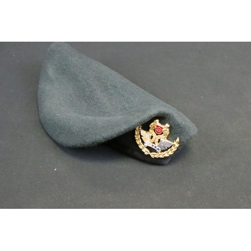 433 - A collection of ten military caps and berets together with associated badges to include Ukraine Army... 