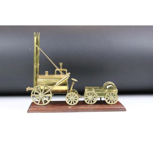 180 - Brass mounted model steam engine featuring a trailer to the back laden with coal. Mounted on a carve... 