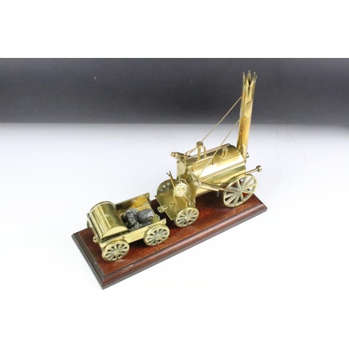 180 - Brass mounted model steam engine featuring a trailer to the back laden with coal. Mounted on a carve... 