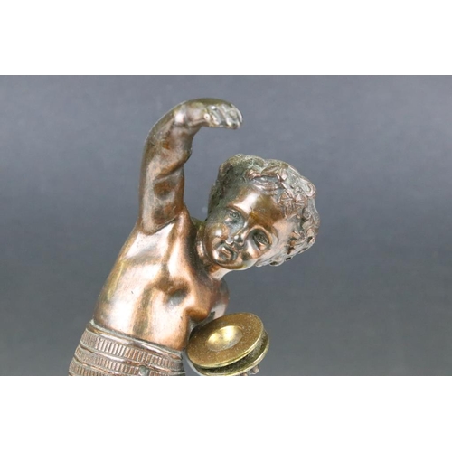 189 - Antique cast bronze putti figurine depicting a classical putti with symbols raised on a fluted cast ... 