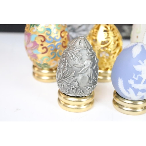 326 - A collection of ornamental eggs to include polished stone and cut glass examples.