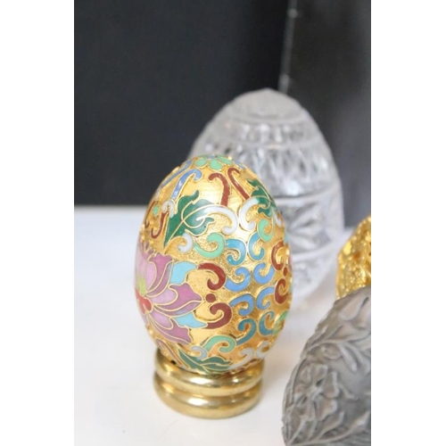 326 - A collection of ornamental eggs to include polished stone and cut glass examples.