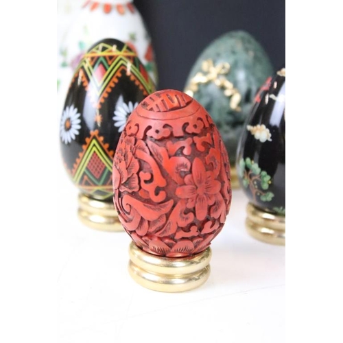 326 - A collection of ornamental eggs to include polished stone and cut glass examples.