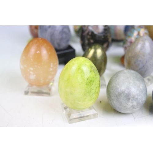 370 - A collection of decorative ornamental eggs to include polished stone and lacquer ware examples.