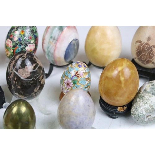 370 - A collection of decorative ornamental eggs to include polished stone and lacquer ware examples.