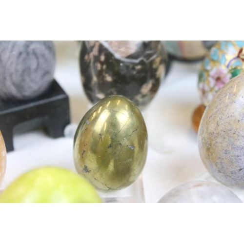 370 - A collection of decorative ornamental eggs to include polished stone and lacquer ware examples.