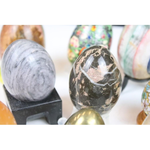 370 - A collection of decorative ornamental eggs to include polished stone and lacquer ware examples.