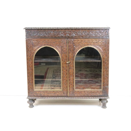 628 - Victorian Oak Display Cabinet with profuse carving, the two doors with domed glazed panels opening t... 