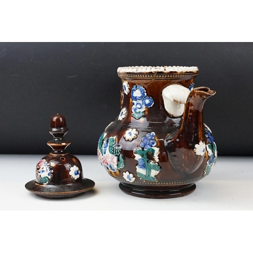 104 - 19th Century Measham pottery bargeware teapot & cover, having typical moulded floral motifs on a bro... 