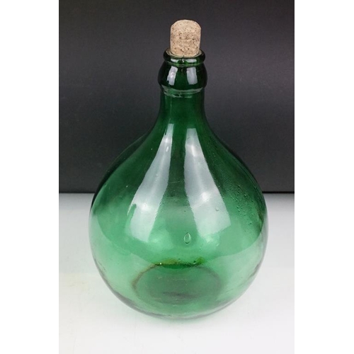 37 - Three green glass bottles / carboys to include a pair of bulbous form (with stoppers) and a further ... 