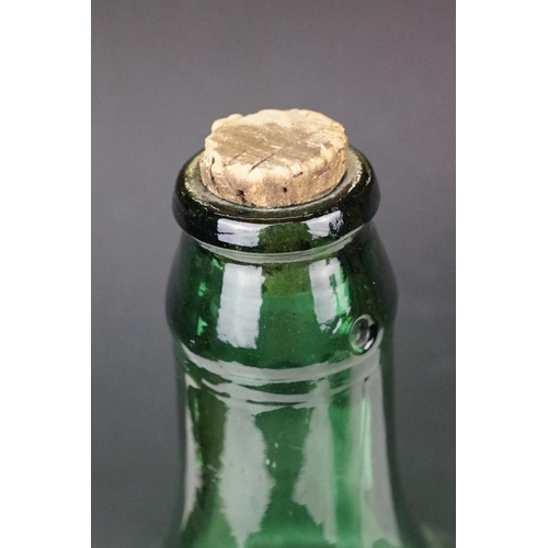 37 - Three green glass bottles / carboys to include a pair of bulbous form (with stoppers) and a further ... 