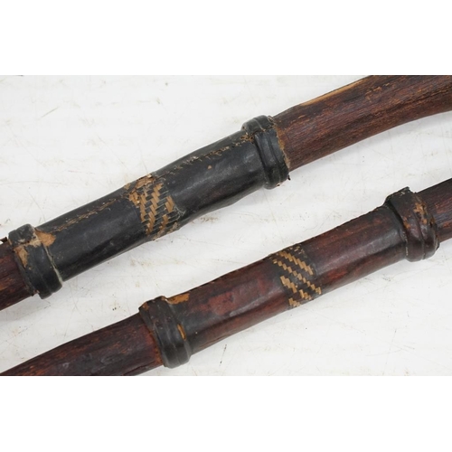 163 - Pair of African wooden tribal spears, with leather handholds and engraved decoration to metal tips, ... 