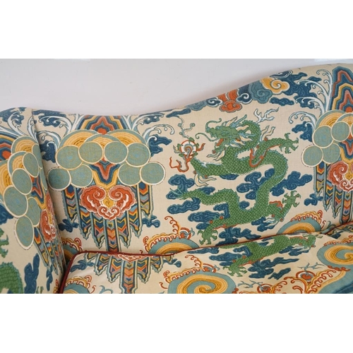 574 - Hump back Settee in the George III manner, with scroll arms, raised on four reeded front legs united... 