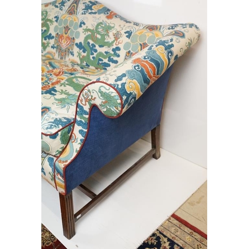 574 - Hump back Settee in the George III manner, with scroll arms, raised on four reeded front legs united... 