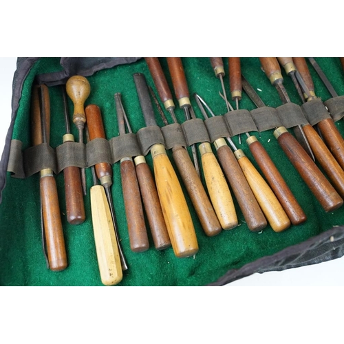 404 - Collection of 39 vintage woodworking chisels, wooden handled, contained within a roll-up case