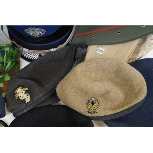 413 - Collection of 20 military caps and berets with associated badges to include Serbia Air Force, Vietna... 