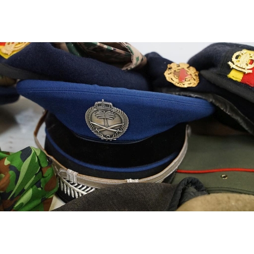 413 - Collection of 20 military caps and berets with associated badges to include Serbia Air Force, Vietna... 