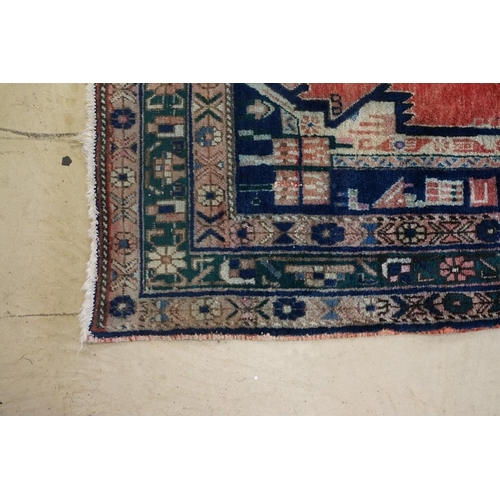 578 - Persian Wool Rug, the red ground with a geometric pattern within a border, 238cm x 160cm