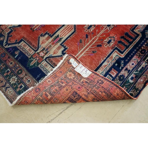 578 - Persian Wool Rug, the red ground with a geometric pattern within a border, 238cm x 160cm