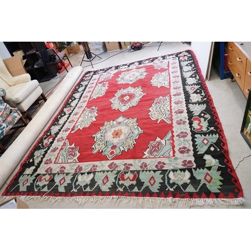 597 - Kilim Gocmen Rug, the red ground decorated with medallions within a black border, 331cm x 224cm