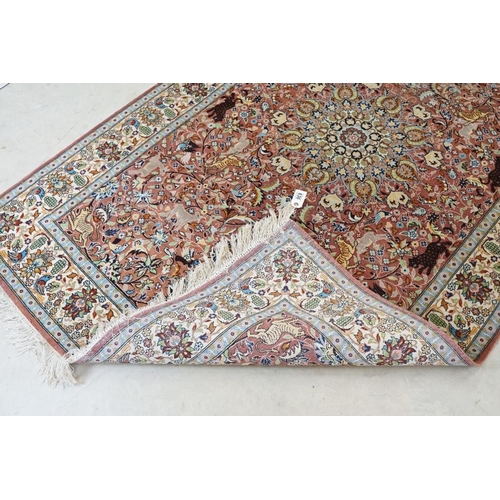 636 - Persian style Rug, the pink ground with a pattern of stylised hunting big cats and deer with birds a... 