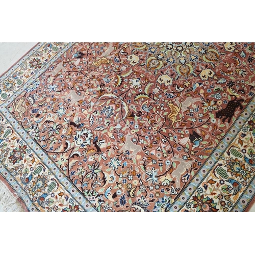 636 - Persian style Rug, the pink ground with a pattern of stylised hunting big cats and deer with birds a... 