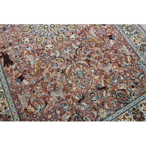 636 - Persian style Rug, the pink ground with a pattern of stylised hunting big cats and deer with birds a... 