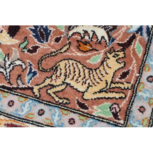 636 - Persian style Rug, the pink ground with a pattern of stylised hunting big cats and deer with birds a... 