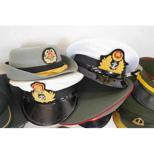 433 - A collection of ten military caps and berets together with associated badges to include Ukraine Army... 