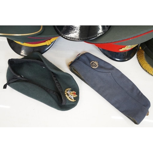 433 - A collection of ten military caps and berets together with associated badges to include Ukraine Army... 