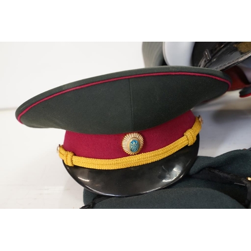 433 - A collection of ten military caps and berets together with associated badges to include Ukraine Army... 