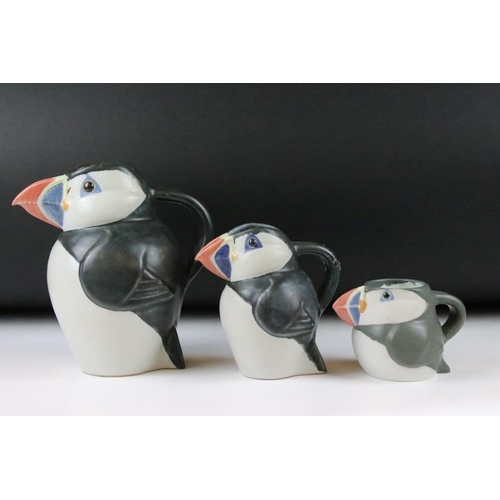 1 - Three graduating John O'Groats pottery puffin jugs. Each moulded into the form of a puffin with hand... 