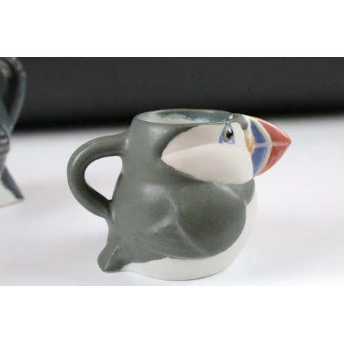 1 - Three graduating John O'Groats pottery puffin jugs. Each moulded into the form of a puffin with hand... 