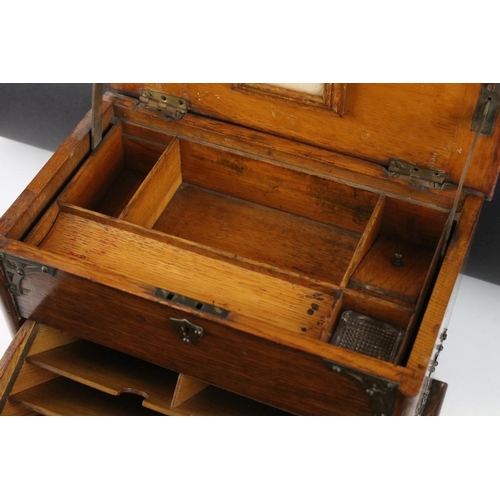 160 - Edwardian oak stationery cabinet, the raising of the lid causing the lower compartment to open, the ... 