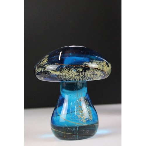 23 - Four pieces of Mdina glass to include a conical paperweight, mushroom paperweight, a tall glass scul... 