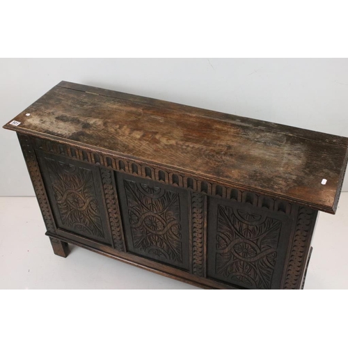 501 - Oak Coffer in the 17th century style with hinged lift lid and three carved panels to front, raised o... 