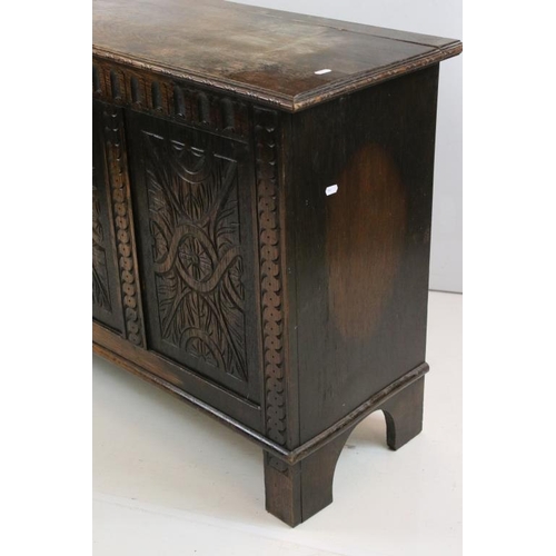 501 - Oak Coffer in the 17th century style with hinged lift lid and three carved panels to front, raised o... 