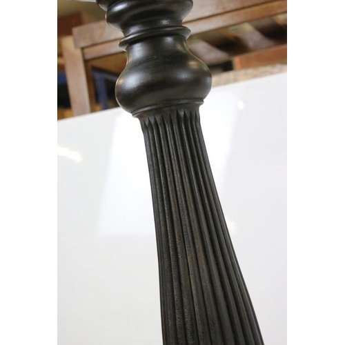 506 - Pair of 19th century Ebonised Jardiniere Stands, each with round tops over carved column supports an... 