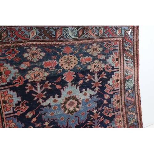 542 - Eastern Wool Blue ground Rug with stylised floral pattern within a border, 138cm x 192cm