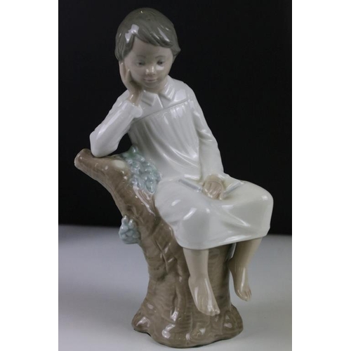 58 - Four Lladro figurines to include a large recumbent clown figure, yawning boy, reading boy and hooded... 