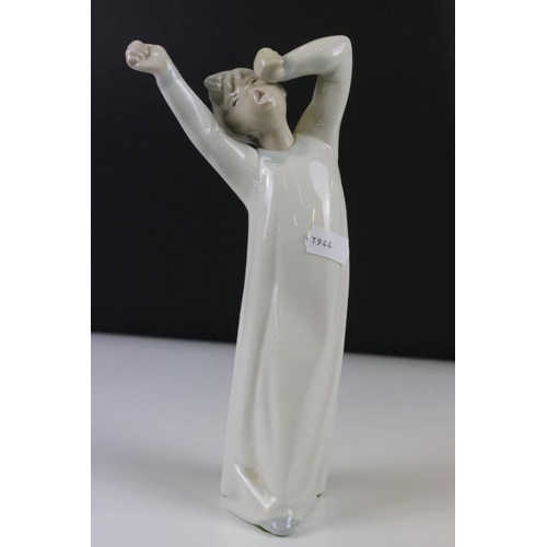 58 - Four Lladro figurines to include a large recumbent clown figure, yawning boy, reading boy and hooded... 