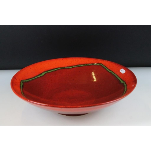 69 - Large Poole pottery red and glazed centrepiece bowl. Signed to verso. Measures approx 36cm diameter.