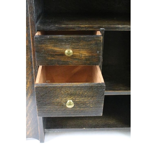 190 - Early-to-mid 20th century oak smokers cabinet of tapering form, the door opening to two drawers and ... 