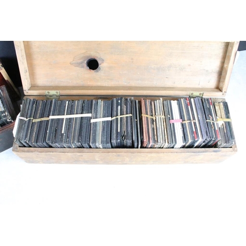 601 - A collection of over 100 magic lantern slides contained within three wooden boxes, mainly people to ... 