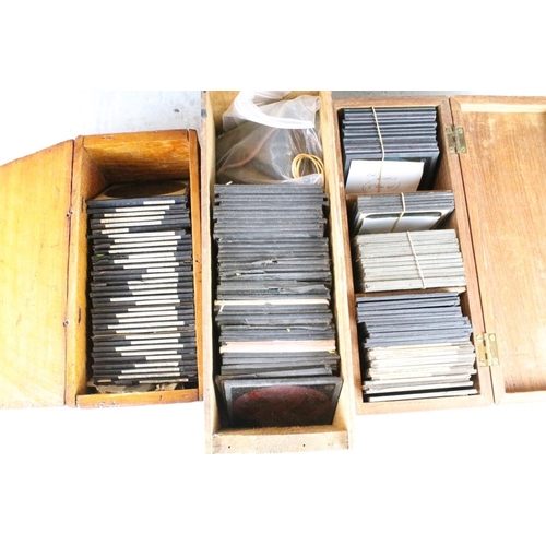 604 - A collection of over 100 glass magic lantern slides contained within three wooden boxes to include W... 